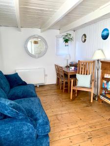 een woonkamer met een blauwe bank en een tafel bij Newlyn Harbour Cottage in Newlyn