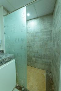 une douche avec une porte vitrée dans une salle de bain dans l'établissement scandic resort 523, à Hurghada