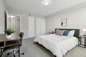 a white bedroom with a bed and a desk and a desk at Halsten At Vinings 2106 Spacious 2bd 15 Bth in Atlanta +18 photos