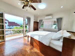 a bedroom with a bed and a large window at Poon house Nimman in Chiang Mai