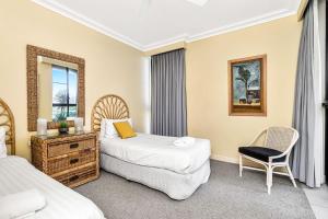 a hotel room with two beds and a chair at Karingal 1 in Lennox Head