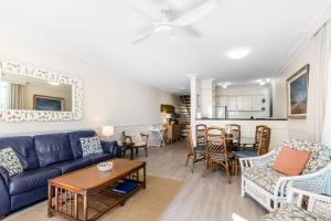 a living room with a blue couch and a table at Karingal 1 in Lennox Head