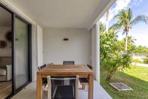 a dining room with a table and a view of the yard at Studio Alamanda Baie Orientale in Orient Bay