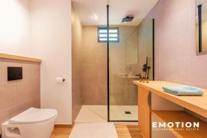 a bathroom with a toilet and a glass shower at Studio Alamanda Baie Orientale in Orient Bay