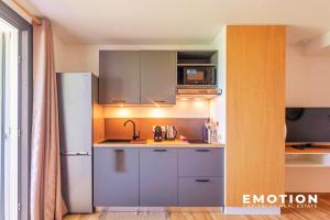 a small kitchen with a refrigerator and a microwave at Studio Alamanda Baie Orientale in Orient Bay