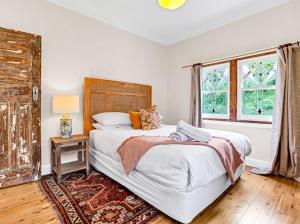 una camera da letto con un letto grande e una finestra di Tranquil Blue Cottage Close to Eco Point a Katoomba