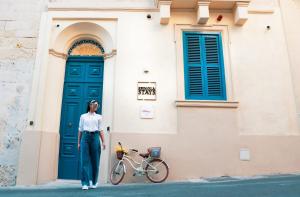 a woman standing next to a bike in front of a building at Spinola Stays in St. Julianʼs