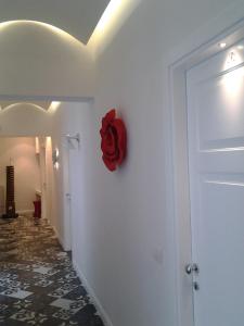 Cette chambre est dotée d'une porte avec une fleur rouge sur le mur. dans l'établissement Arco' B&B, à Trani