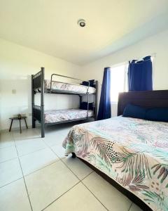 a bedroom with two bunk beds and a tiled floor at Alejandría Depto Moderno - Café Luxury - 3 Min Malecón y Playas in Mazatlán