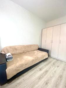 a couch in a room with white cabinets at Комфортабельные - уютные апартаменты в Костанай Береке 63 in Kostanay
