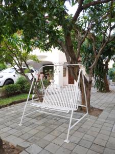 a white chair sitting in front of a tree at Poon house Nimman in Chiang Mai +25 photos