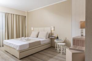 Кровать или кровати в номере Ammos Beach Seaside Luxury Suites Hotel