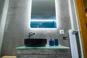 ein Badezimmer mit einem schwarzen Waschbecken und einem Spiegel in der Unterkunft Serenity and 2 bedroom Luxury in Kalamaria in Thessaloniki