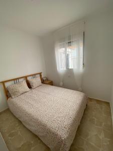 a bedroom with a bed in a room with a window at Santa Ana in Novo Sancti Petri