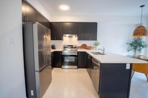 a kitchen with black cabinets and stainless steel appliances at The Cozy Corner in Hamilton