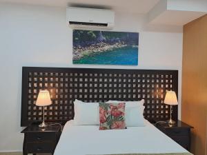 a bedroom with a white bed with two night stands and two lamps at Hotel SQUARE in Sertã +48 photos