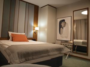 een hotelkamer met een bed en een spiegel bij Gvarna Apartamenty in Wrocław