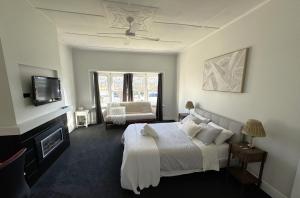 una camera con letto, camino e TV di Heritage Charm, Modern Comfort a Ballarat