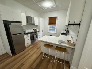 una cucina con bancone bianco e frigorifero di Heritage Charm, Modern Comfort a Ballarat