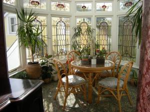 a room with a table and chairs and stained glass windows at Headlands Hotel in Llandudno