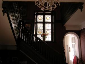 a stairway with a chandelier and a window at Headlands Hotel in Llandudno
