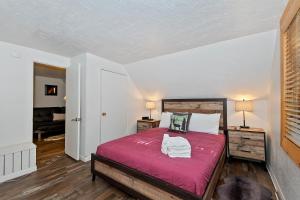 een slaapkamer met een bed met een rode sprei bij NEW- Red Robin W hot tub in Big Bear Lake
