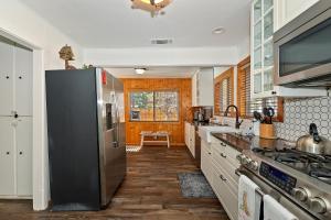 een keuken met een roestvrijstalen koelkast en houten vloeren bij NEW- Red Robin W hot tub in Big Bear Lake