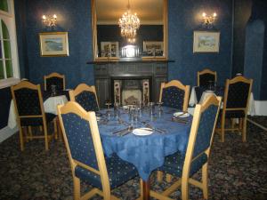 a dining room with a table and a fireplace at Headlands Hotel in Llandudno