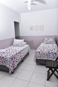 a bedroom with two beds and a fan at Casa da Vó Maria 10 in Goiânia