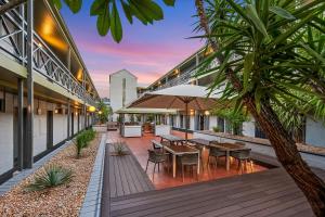 an outdoor patio with tables and chairs in a building at Mantra Alice Springs in Alice Springs