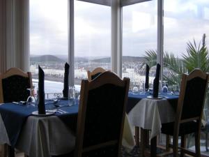 a dining room with tables and chairs and a window at Headlands Hotel in Llandudno