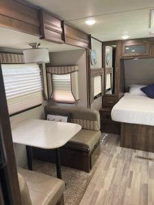 タラハシーにあるCozy Caravan near Capitol FSU FAMUのベッドとテーブルのある小さな部屋