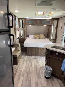 タラハシーにあるCozy Caravan near Capitol FSU FAMUの小さな客室で、ベッド1台、洗面台(RV内)が備わります。