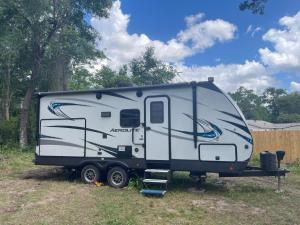 タラハシーにあるCozy Caravan near Capitol FSU FAMUの野原に駐車された白黒のトレーラー