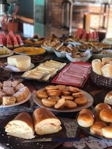 a table full of different types of breads and pastries at Pousada Brilho da Natureza in Visconde De Maua
