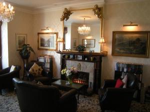 a living room with couches and a fireplace and a mirror at Headlands Hotel in Llandudno
