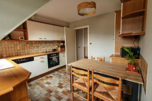 a kitchen with a wooden table and chairs at Rayon du Soleil in Wintzenheim