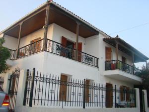 a white house with balconies and a fence at Ioanna's traditional apartment in Elia Laconias