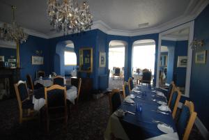 a dining room with blue walls and tables and chairs at Headlands Hotel in Llandudno