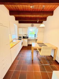 una cucina con mobili bianchi e un tavolo di legno di 2 Zimmer Business Wohnung mit Terrasse a Ahrensburg