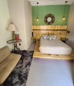 une chambre avec un lit, un canapé et une table dans l'établissement Casa Tatewari, à San Luis Potosí