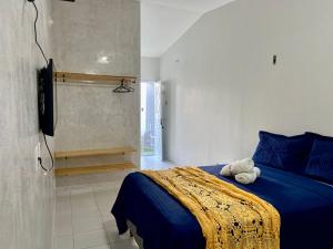 a bedroom with a blue bed and a walk in shower at Studio Bia in Natal