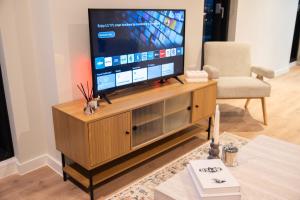 a television on a wooden entertainment center in a living room at Modern Apartment in Central Manchester in Manchester