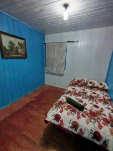 een slaapkamer met een bed met bloemen erop bij Quarto Cama Casal in Gramado