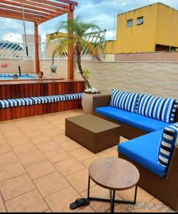 a blue couch and a table on a patio at Suíte na Cobertura Enseada in Guarujá