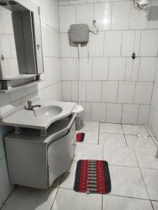 a bathroom with a sink and a toilet at Quarto Cama Casal in Gramado