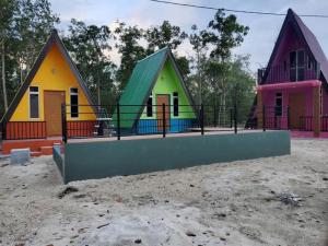 a group of small colorful houses in a field at Lading Amas Resort in Rengit