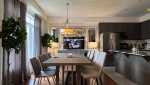 a kitchen with a table and chairs and a refrigerator at 9 Queen Beds, 18 Guests-Kleinburg Luxe Crown Town Residence in Vaughan