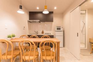 a kitchen and dining room with a wooden table and chairs at coconehouse namba family type in Osaka