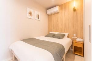 une petite chambre avec deux lits et un radiateur dans l'établissement coconehouse namba family type, à Osaka